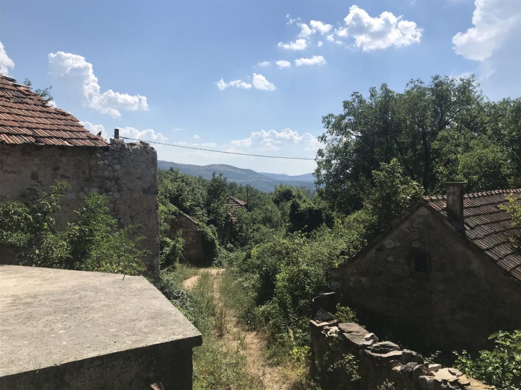 Houses stand alongside ruins of homes in the hamlet of Grubori. Photo: BIRN.